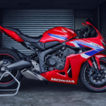 A striking front view of the 2025 Honda CBR650R in Grand Prix Red, showcasing its aggressive design, LED headlights, and aerodynamic styling.