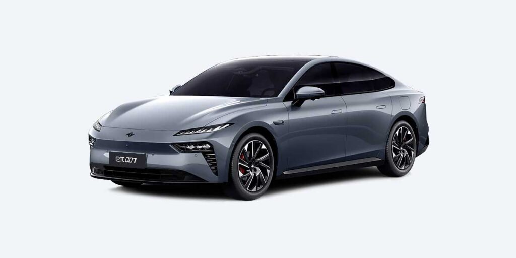 Sleek Dongfeng eπ 007 electric sedan in Night Shadow Black, showcasing its aerodynamic fastback design, split LED headlights with 104 LEDs, and optional electric scissor doors, parked against a modern city backdrop.